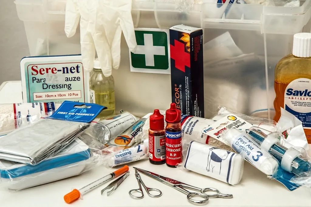 First-aid kit supplies laid out on a table, including gloves, dressings and medicines