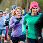 Group of adults jogging together on a wooded trail
